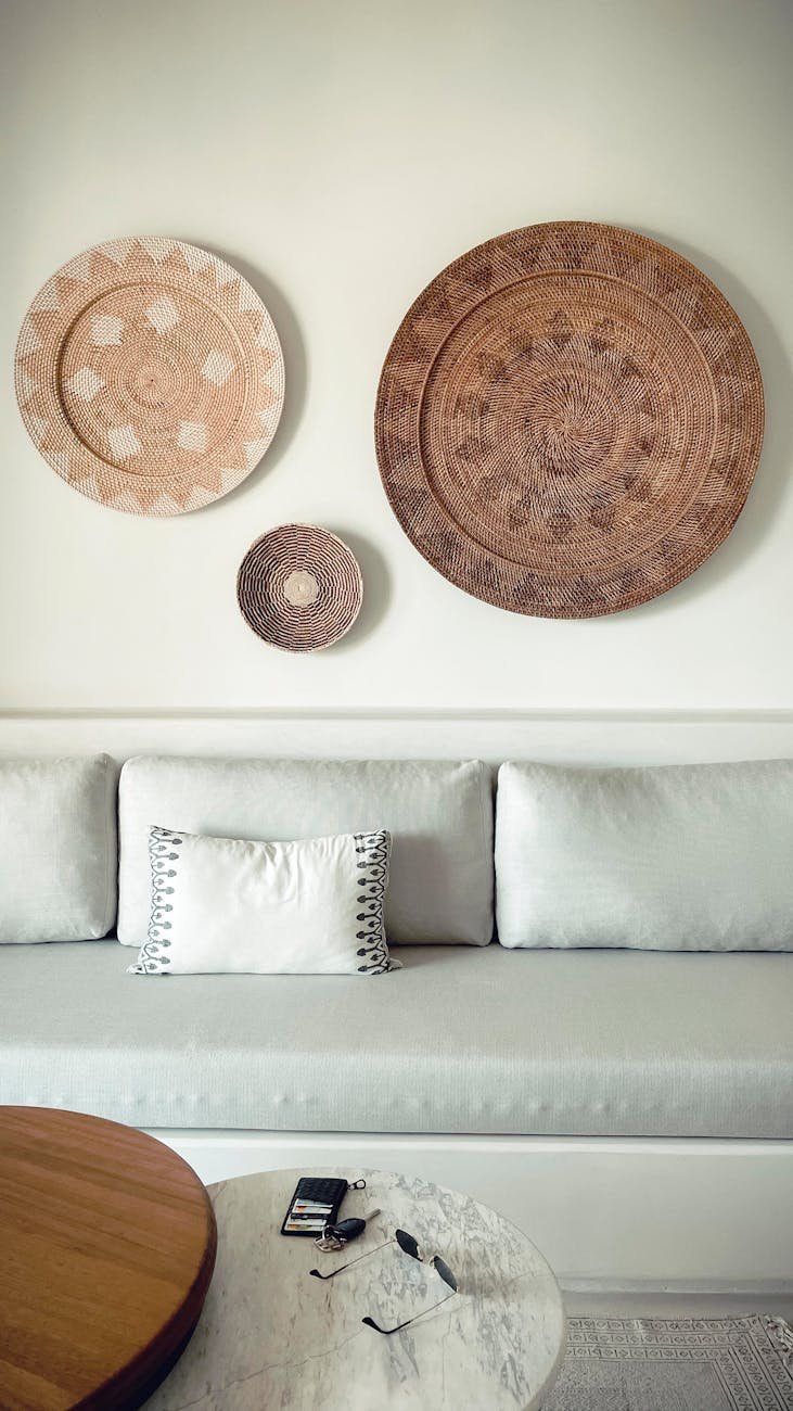 three decorative plates on a wall over a couch