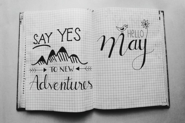 Black and white image of an open journal featuring motivational quotes and artistic doodles.