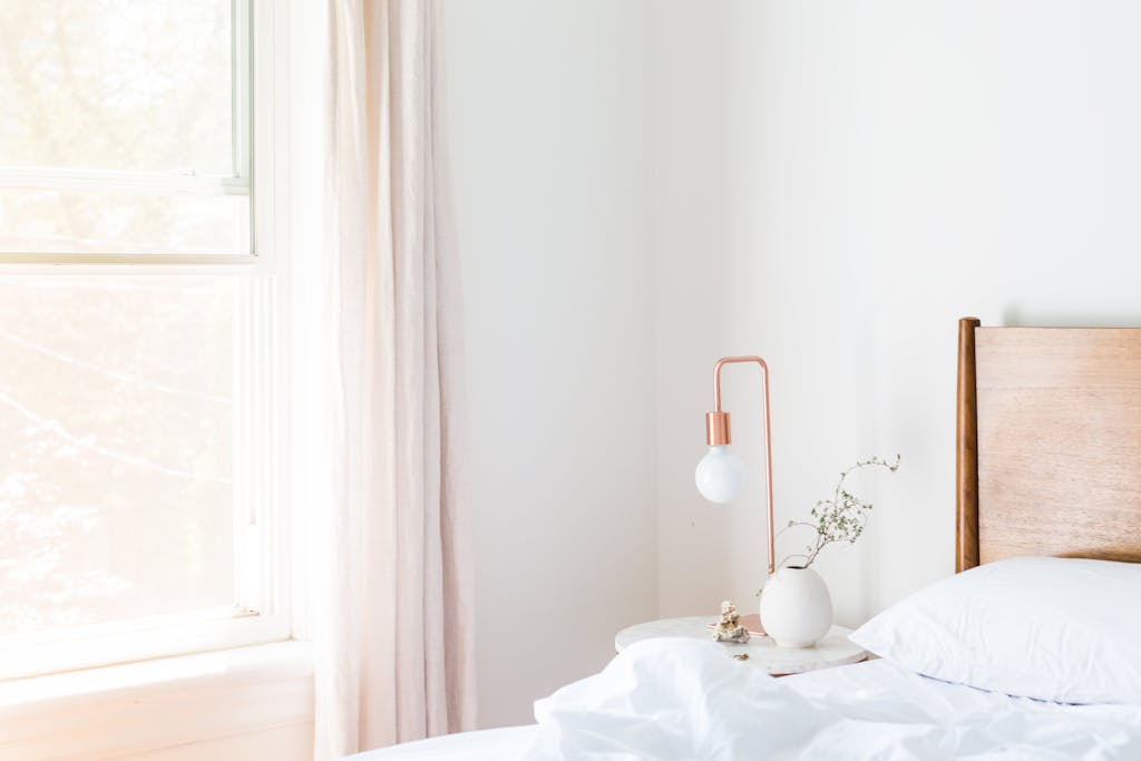 Bright minimalist bedroom with modern furniture and natural lighting.
